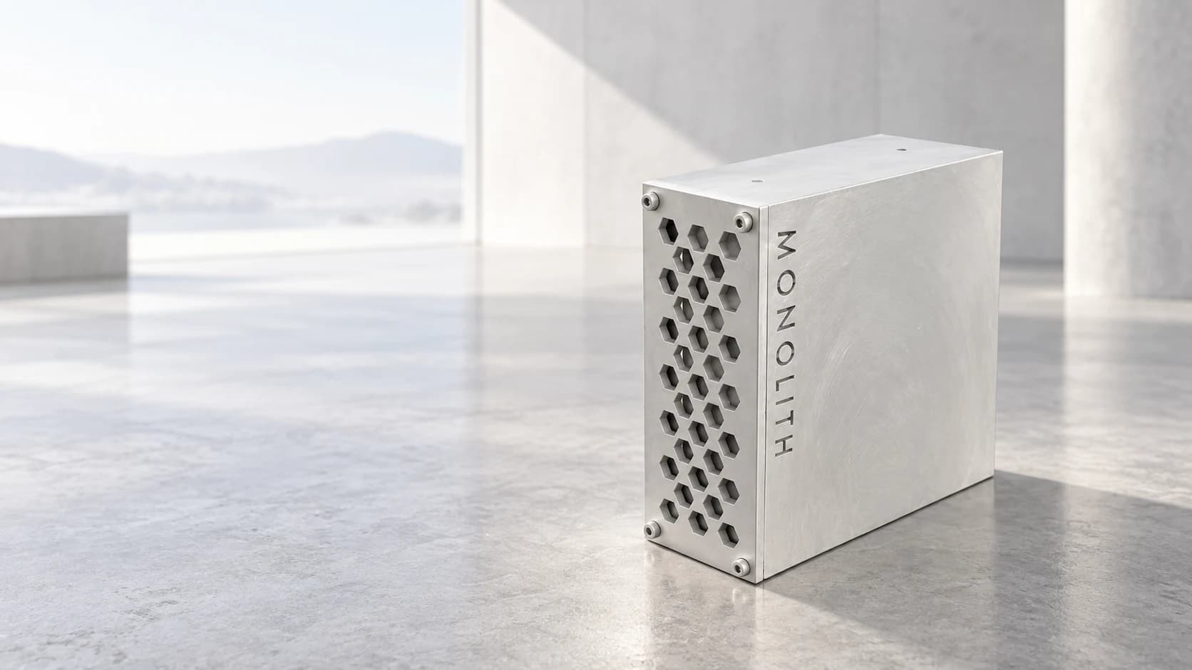 One brushed-aluminium Monolith enclosure with engraved vertical MONOLITH lettering in a light-filled architectural studio; concept render from the prototype